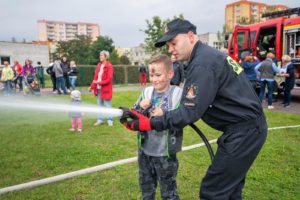 Strażak i dziecko trzymający wąż gaśniczy